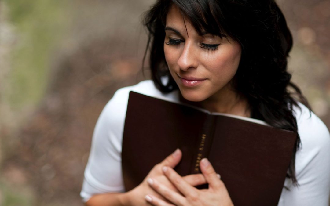 woman wearing white holding a Bible